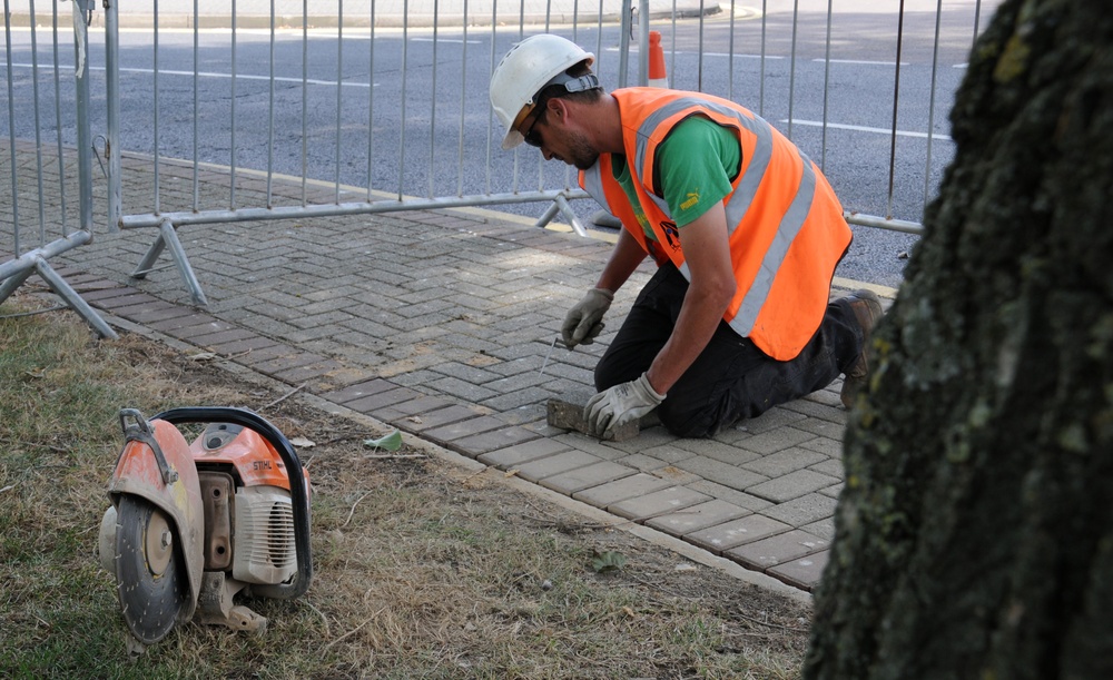 Contractors level sidewalk, ensures safety for pedestrians