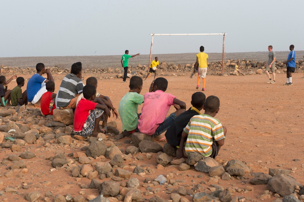 Djiboutian children watch service members play soccer