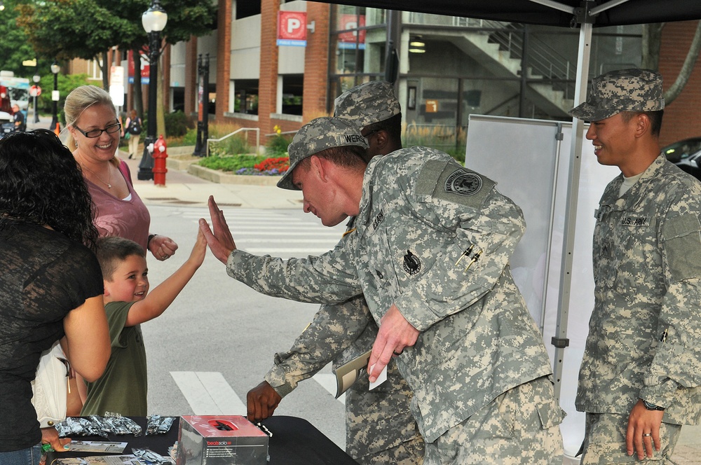 Soldier high-fives with local child at National Night Out