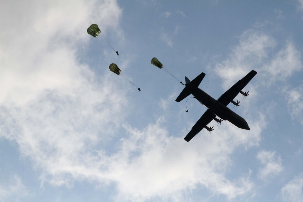 Paratroopers jump out of a Canadian C-130J Hercules