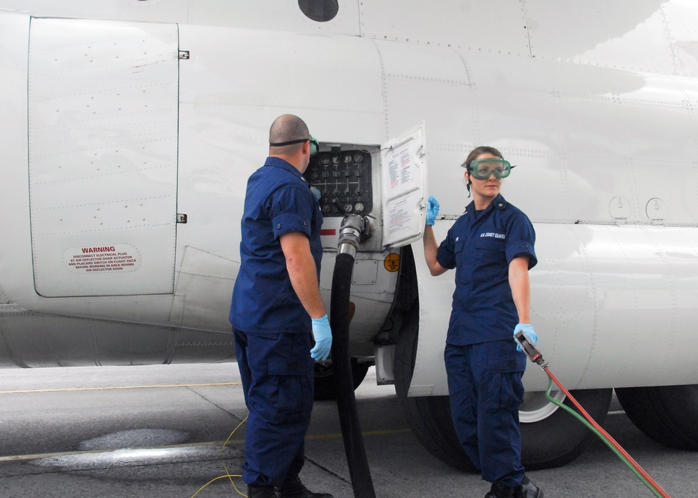 Coast Guard avionics electrical technicians, refuel an HC-130 Hercules aircraft in Kodiak, Alaska