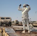 Soldier guides a Humvee across freight cars