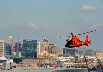 Coast Guard Air Station Atlantic City MH-65 Dolphin crew flies over Baltimore’s Inner Harbor as Star-Spangled Spectacular draws to a close