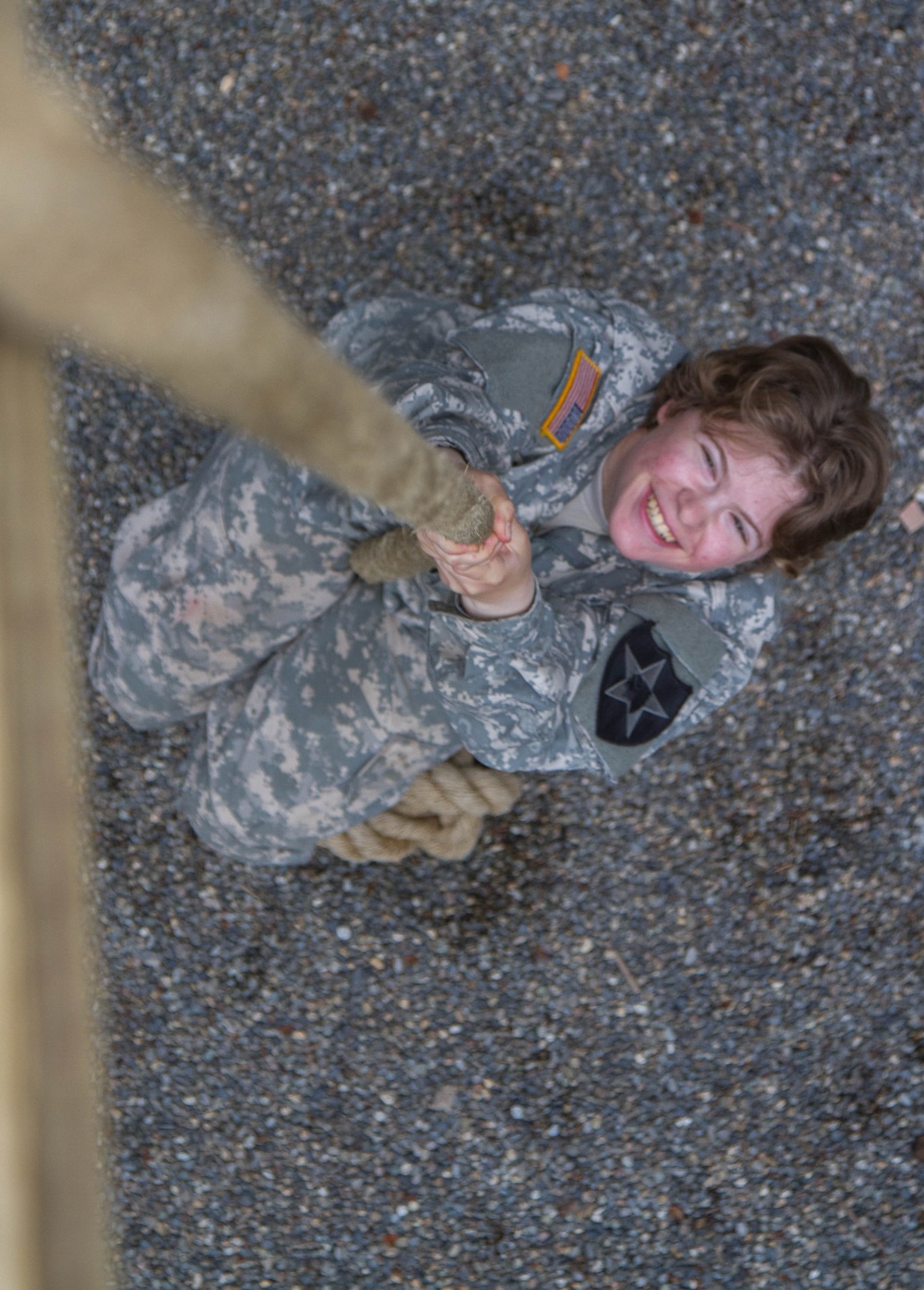 Soldier climbs obstacle in Sisters in Arms event
