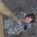Soldier climbs obstacle in Sisters in Arms event