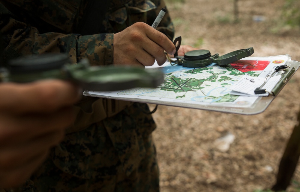 Parris Island recruits guide themselves through wooded areas using a map, compass