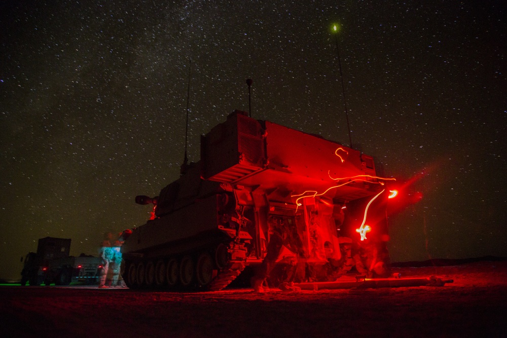 Soldiers patrol with an M109A6 throughout the night