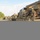 1st Cavalry arrives in Poland A military convoy is staged along a road, featuring multiple desert-tan painted armored vehicles including what appear to be Bradley Fighting Vehicles and a heavy recovery/engineering vehicle in the foreground. Several soldiers in camouflage uniforms are visible standing near the vehicles, with one individual wearing a high-visibility vest. The setting appears to be a European road environment based on the street lighting style and surrounding vegetation.