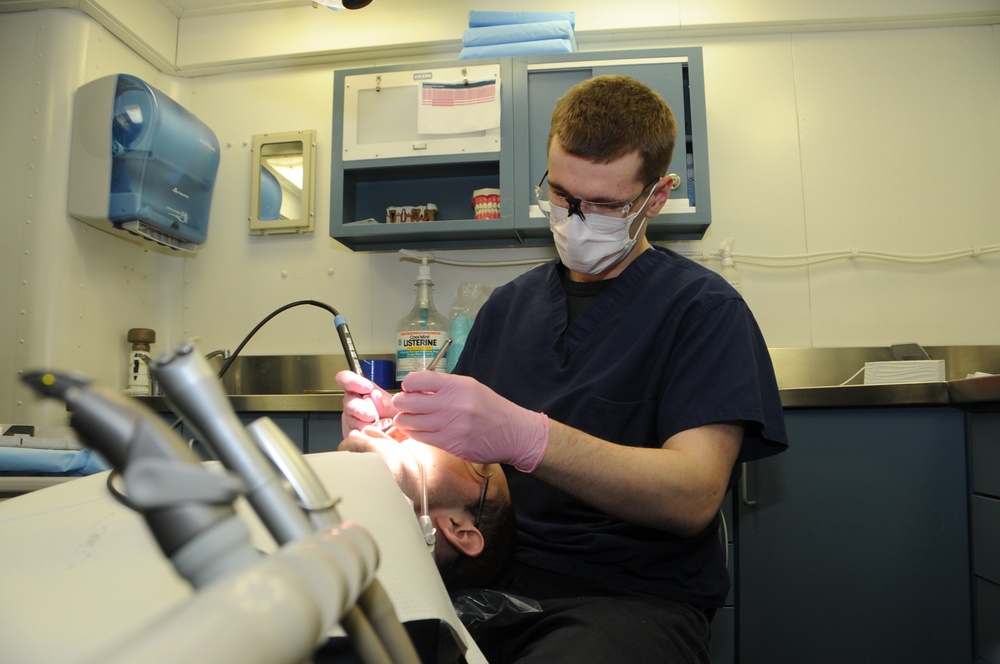 USS George H.W. Bush Sailor performs dental checkup