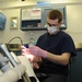 USS George H.W. Bush Sailor performs dental checkup