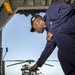 USS Philippine Sea Sailor performs maintenance on a helicopter rapid securing device