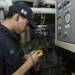 USS Mason sailor collects readings in engine room