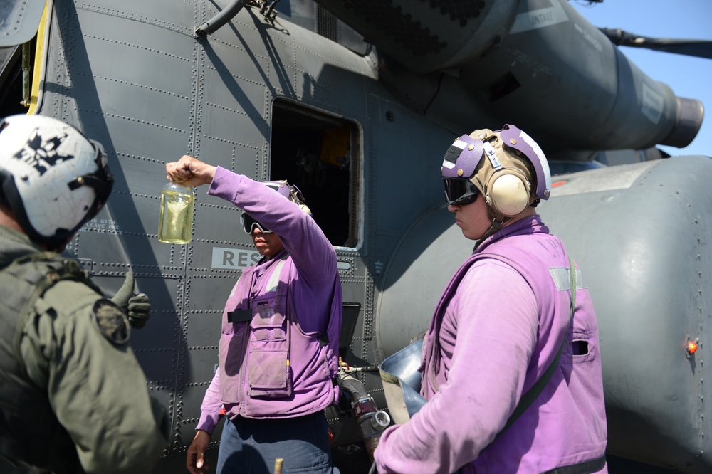 USS Mesa Verde Sailor takes fuel sample