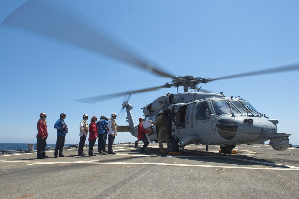 Sailors unload mail from an MH-60S Seahawk helicopter