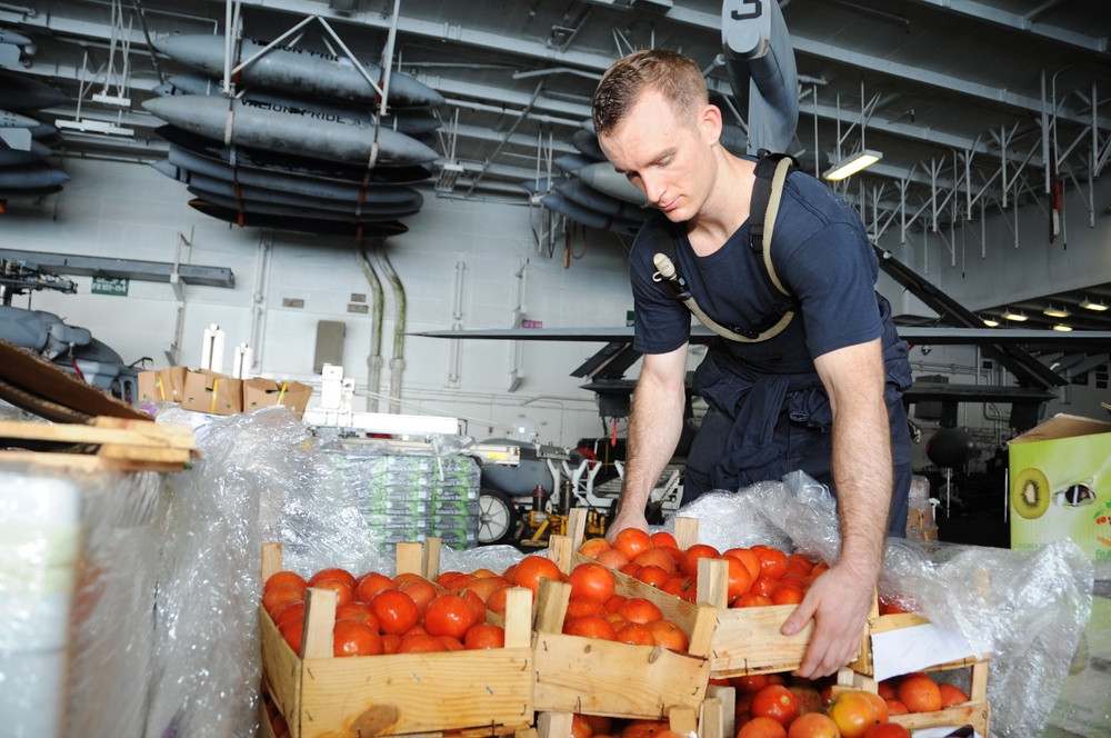 USS George H.W. Bush sailor moves crates