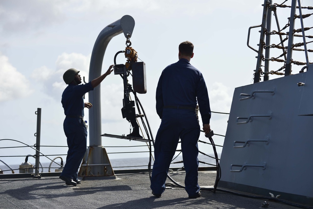 Sailors lower machine gune