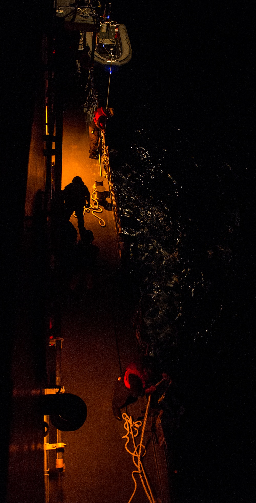 Sailors launch RHIB during nighttime boat operations