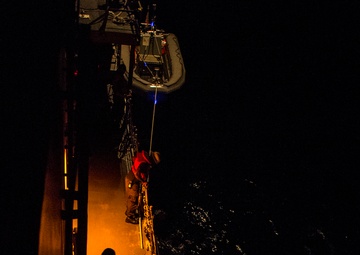 Sailors launch RHIB during nighttime boat operations