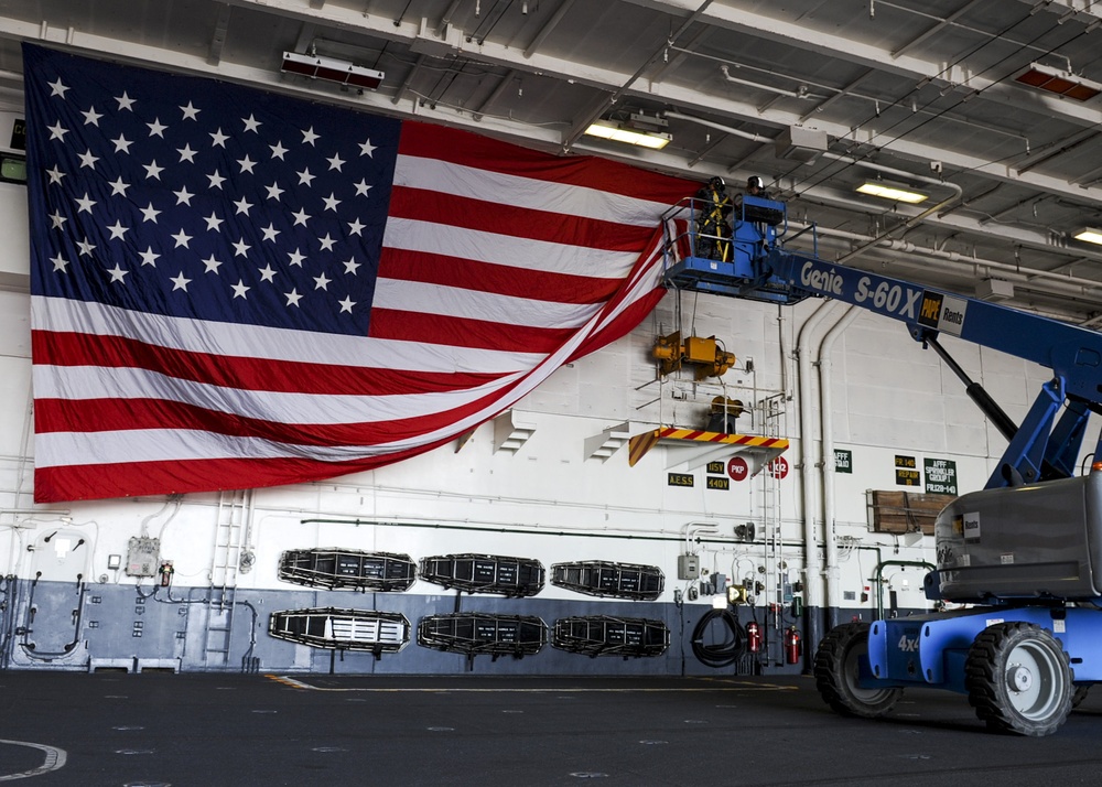 USS Nimitz sailors hang flag before change of command ceremony