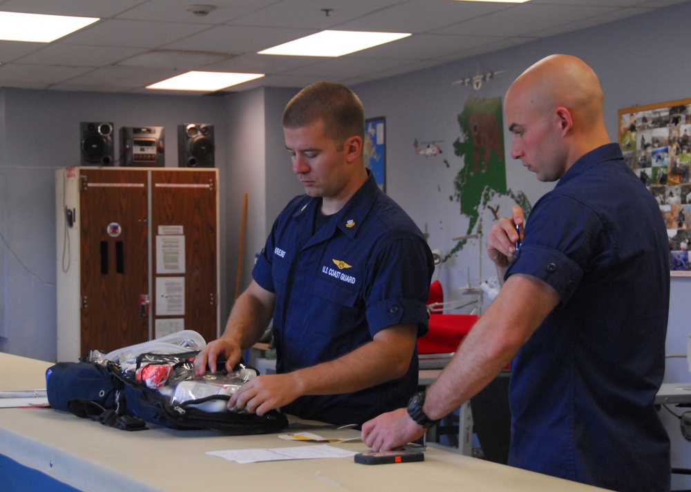Coast Guard aviation survival technicians prepare emergency medical gear and supplies for missions at Air Station Kodiak, Alaska
