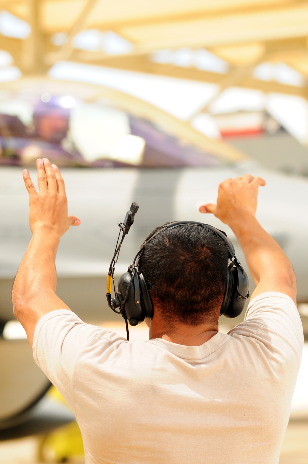 Crew chief marshals an F-16 Fighting Falcon aircraft