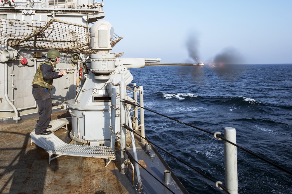 USS Philippine Sea Sailor fires 25 mm machine gun