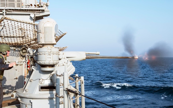 USS Philippine Sea Sailor fires 25 mm machine gun