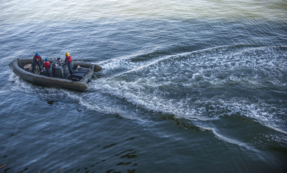 Sailors operate a rigid-hull inflatable boat