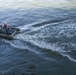 Sailors operate a rigid-hull inflatable boat