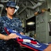 USS George H.W. Bush sailor folds flag