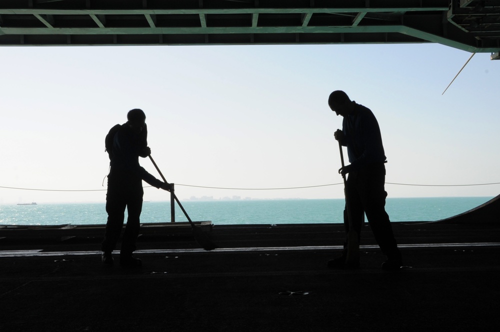 USS George H.W. Bush sailors sweep hangar bay