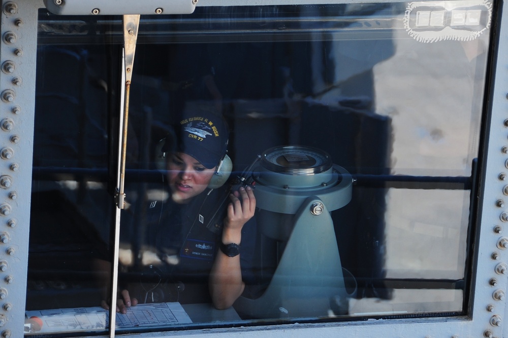 USS George H.W. Bush Sailor stands phone talker watch