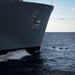 Dolphins swim alongside Arleigh Burke