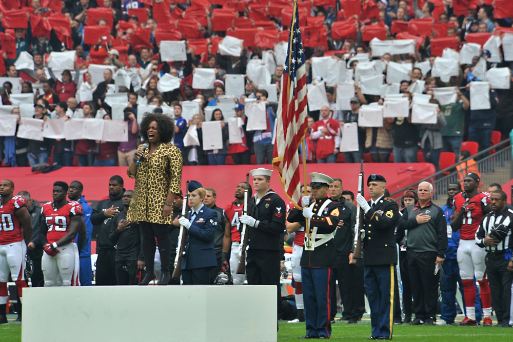 US service members present US flag at NFL game
