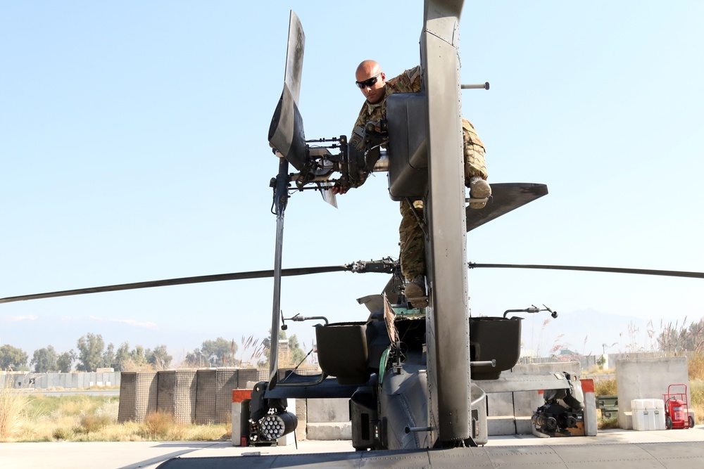 Soldier doing AH-64 Apache tail rotor inspection before pilots conduct their pre-flight inspection.
