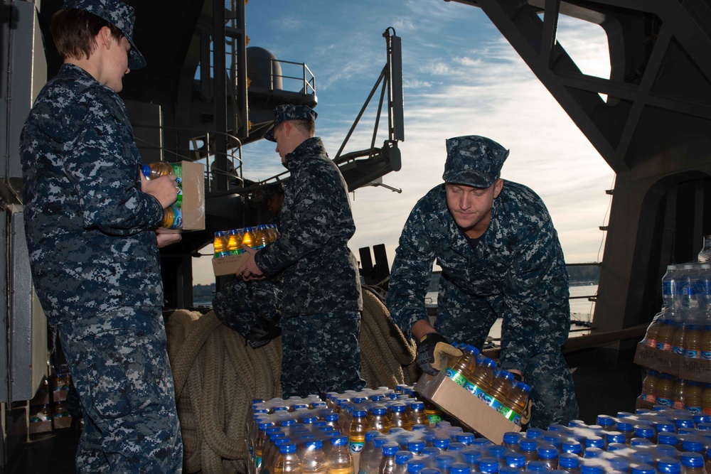 USS John C. Stennis Sailors move supplies to a cargo hold