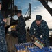USS John C. Stennis Sailors move supplies to a cargo hold