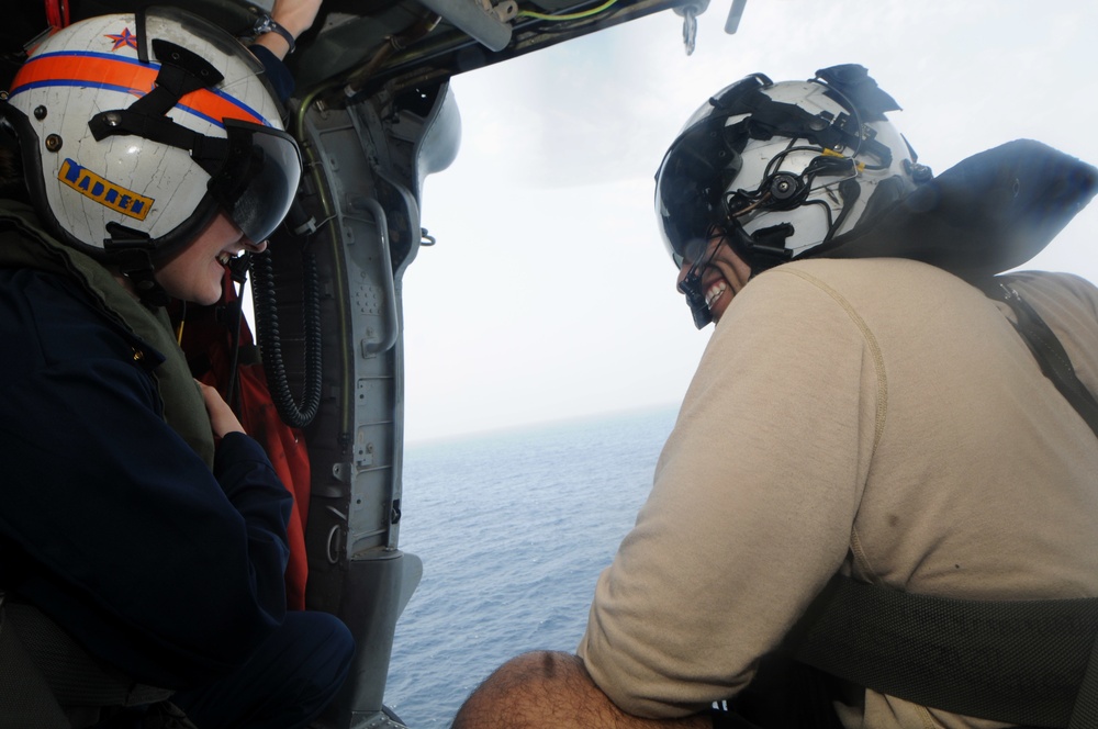 Helicopter Sea Combat Squadron 6 Seahawk aircrewman shows shows midshipman how to use the rappel cable