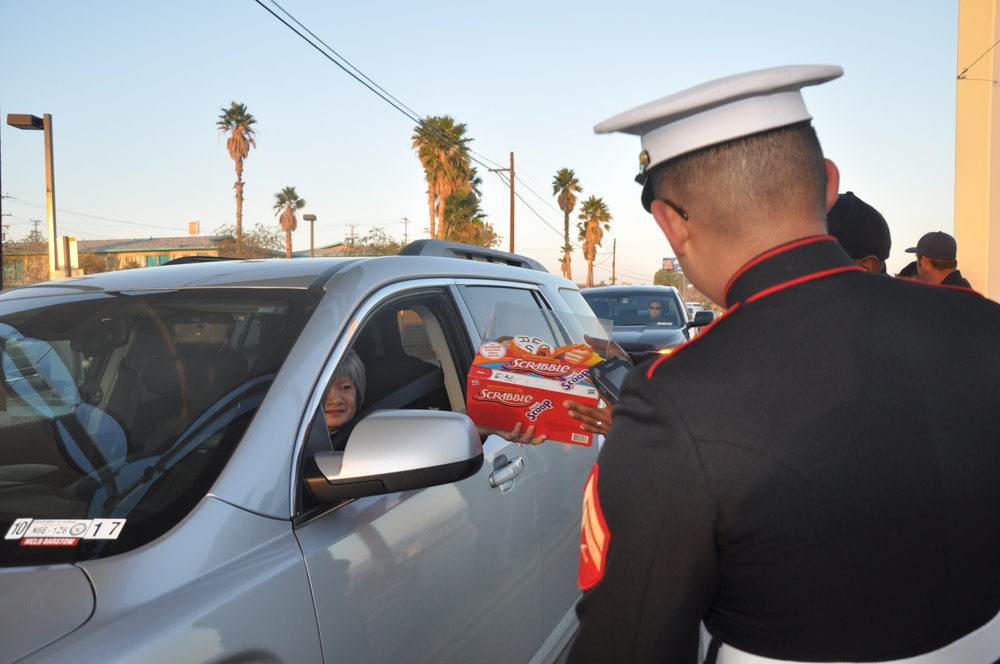 Marines and fire fighters receive toys and cash donations to benefit the Toys for Tots program at the entrance gate to Marine Corps Logistics Base Barstow, Dec. 9.  The toys will be distributed to High Desert families in need, in time for Christmas.