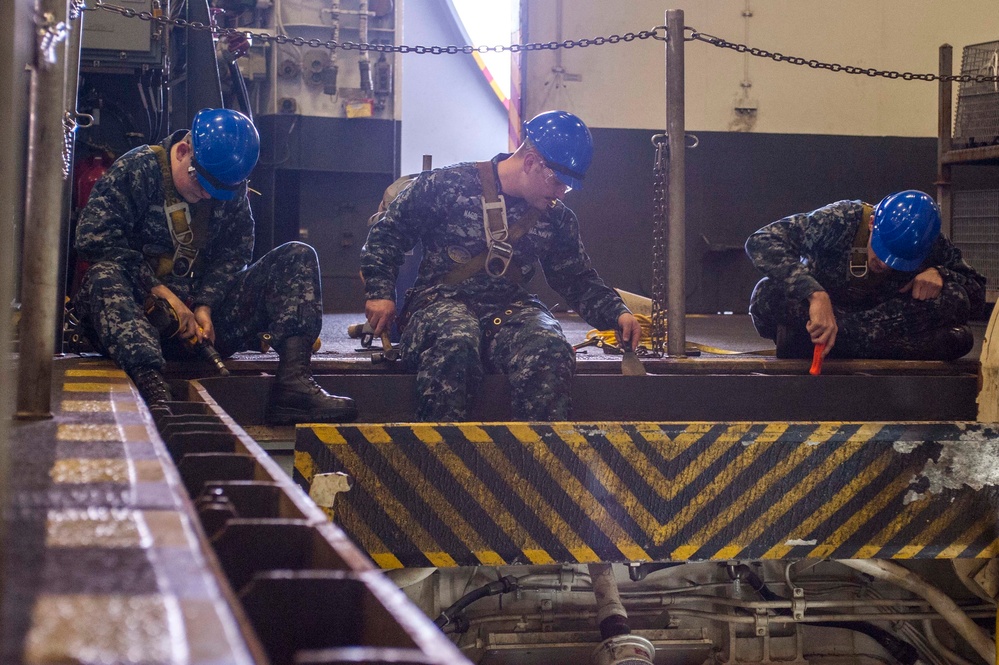 USS Harry S. Truman Sailors clean an elevator trough
