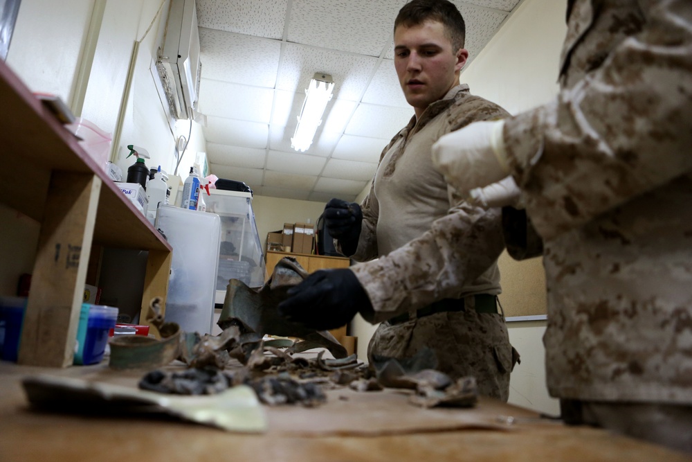 U.S. Marine Lance Cpl. Logan E. Dehnhoff, with the Exploitation Analysis CenterLaw Enforcement Detachment, Special Purpose Marine Air Ground Task Force-Crisis Response-Central Command, pieces together a fuse from exploded ordnance Dec. 28, 2014.