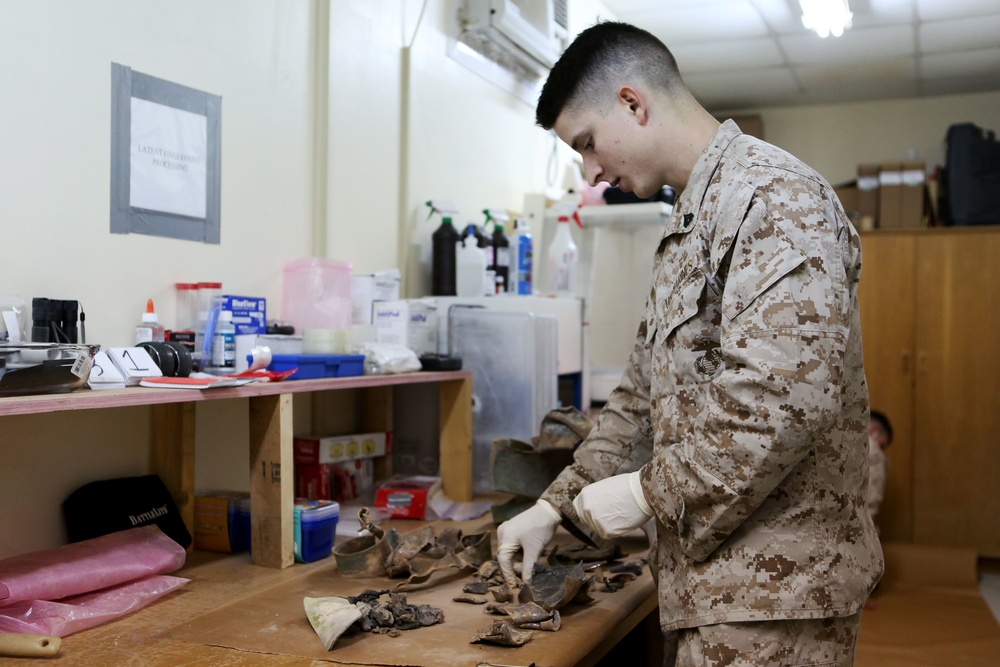 Marine Cpl. Blake A. Wintch with the Exploitation Analysis Center, Special Purpose Marine Air Ground Task Force-Crisis Response-Central Command, organizes exploded ordnance Dec. 28, 2014.