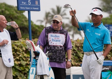 US military service members caddie for pro golfers during Sony Open in Hawaii Pro-Am Tournament