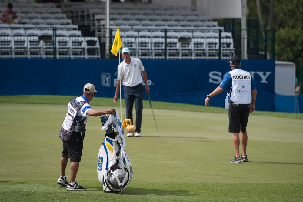 US military service members caddie for pro golfers during Sony Open in Hawaii Pro-Am Tournament