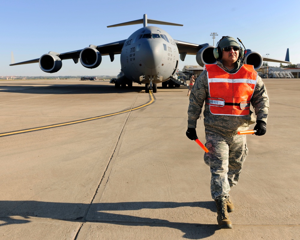 728th Air Mobility Squadron members process cargo from a C-17 Globemaster III