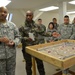 Sous-Lieutenant Fabrice Guy briefs the 557th ASMC, utilizing his sand table for orientation