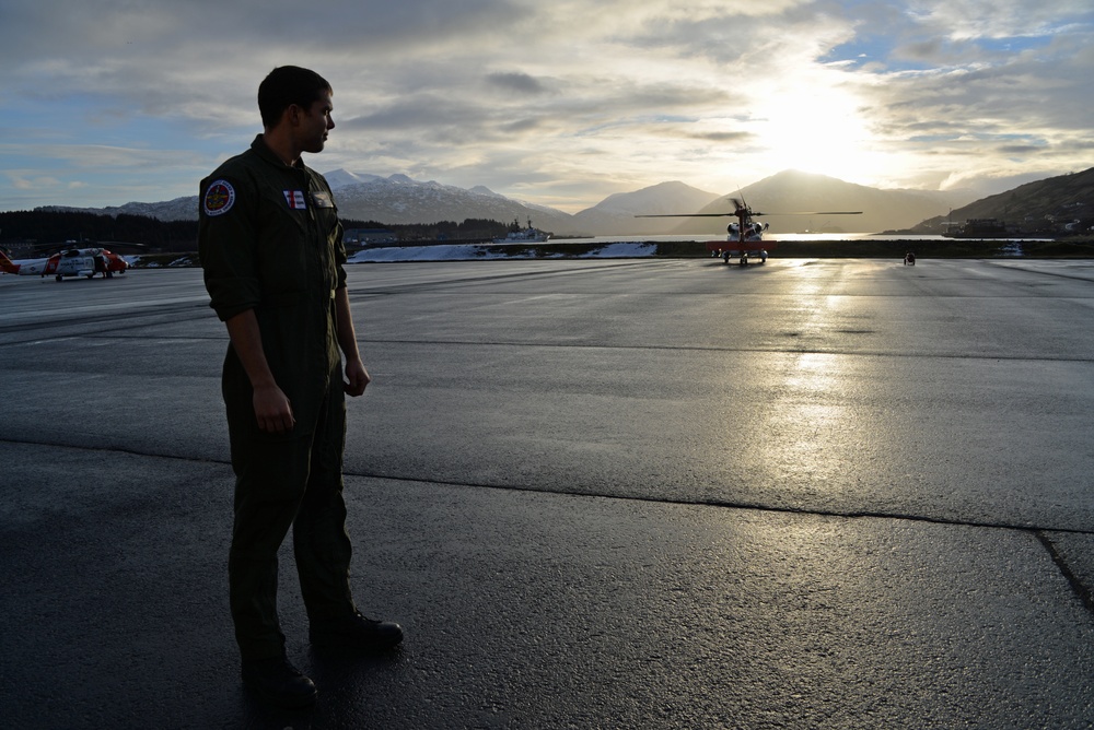 Coast Guard aviation survival technician arrives on the flight line at sunset to stand duty in Kodiak, Alaska