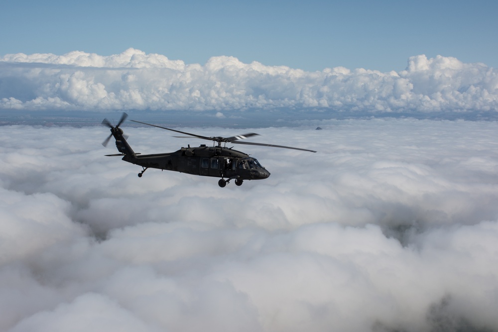 Black Hawk soars over clouds
