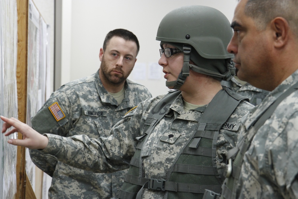 Brig. Gen. Jon D. Lee listens to an intelligence brief from the 90th Sustainment Brigade