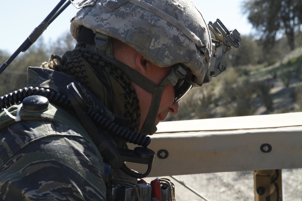 The 8th Squadron 1st US Cavalry sits in the back of a High Mobility Multi-Purpose Wheeled Vehicle as part of an opposition force (OPFOR)